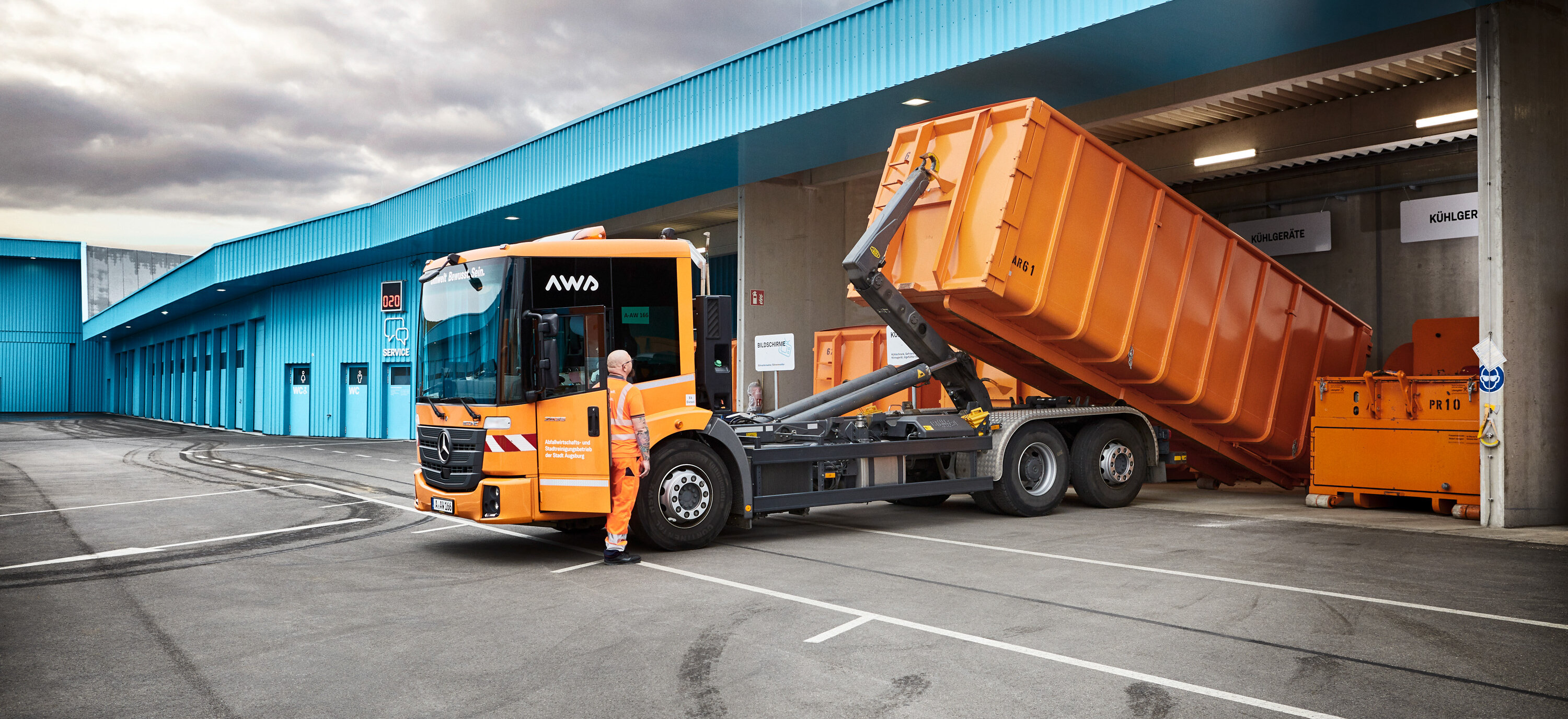 LKW am Wertstoff- & Servicepunkt lädt Container ab