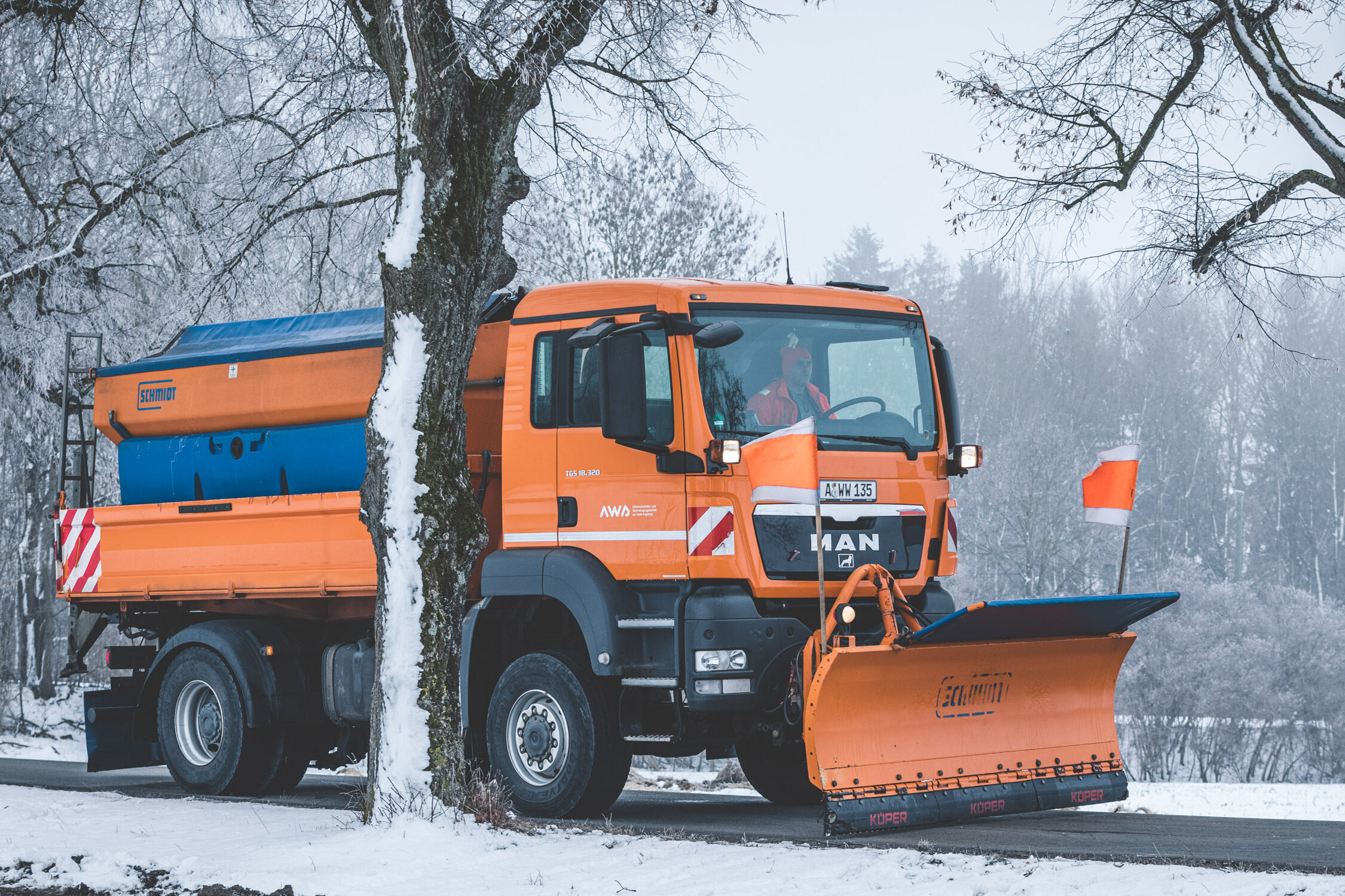 Schneeräumfahrzeug auf winterlicher Straße Schneeräumfahrzeug auf winterlicher Straße