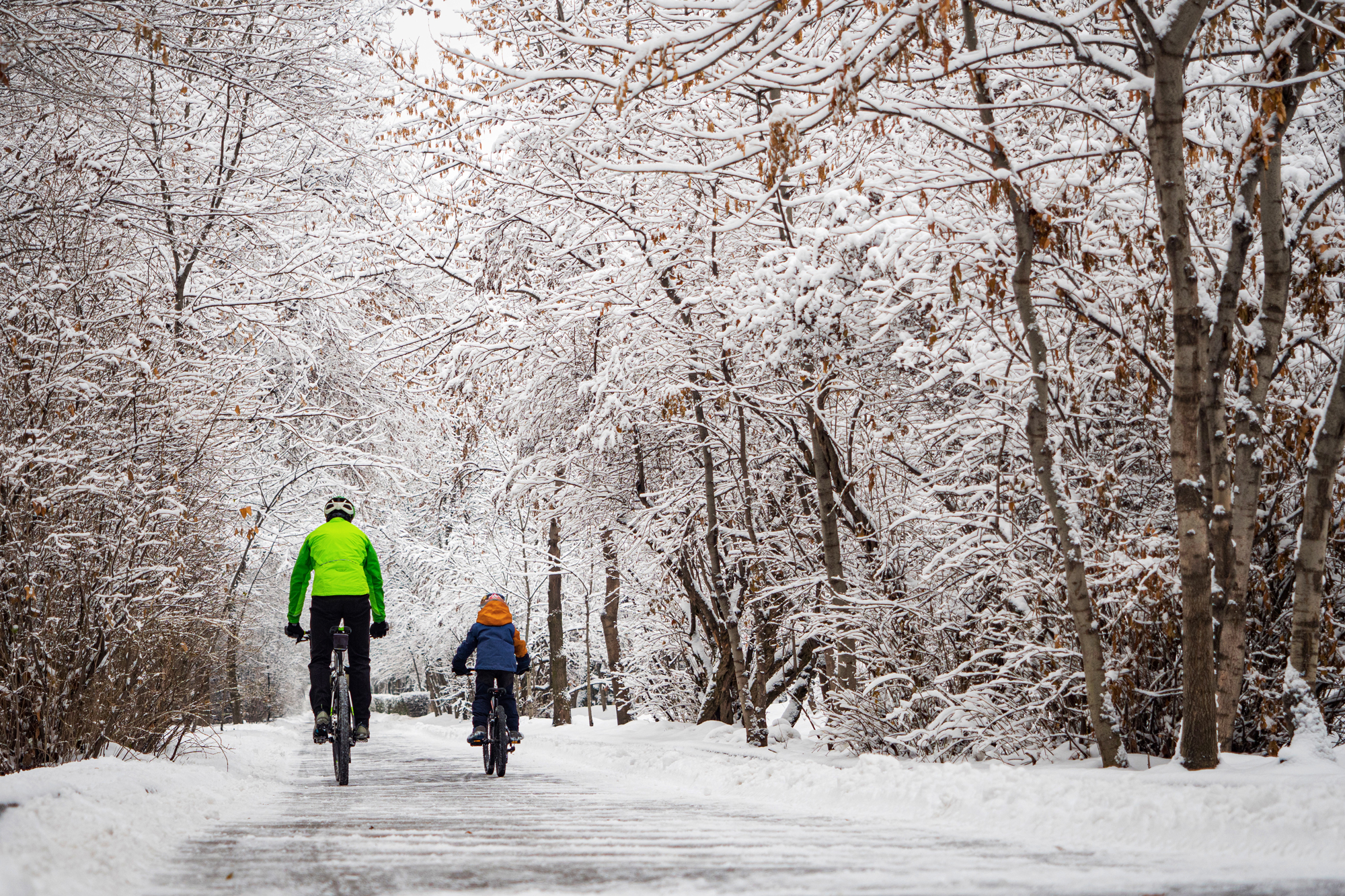 Radfahrer mit Radfahrer Kind auf verschneiter Straße
